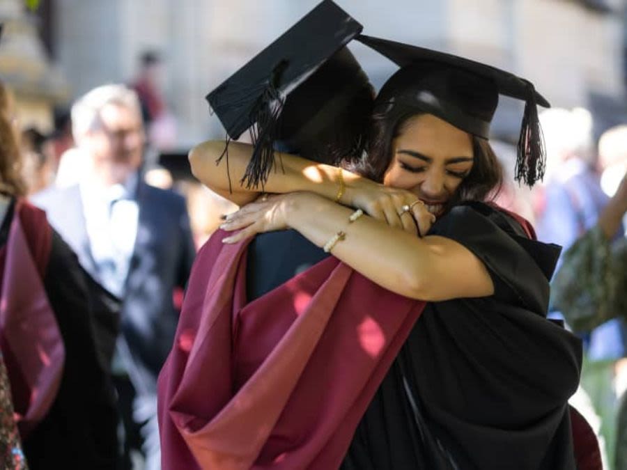 Graduates hugging after their ceremony