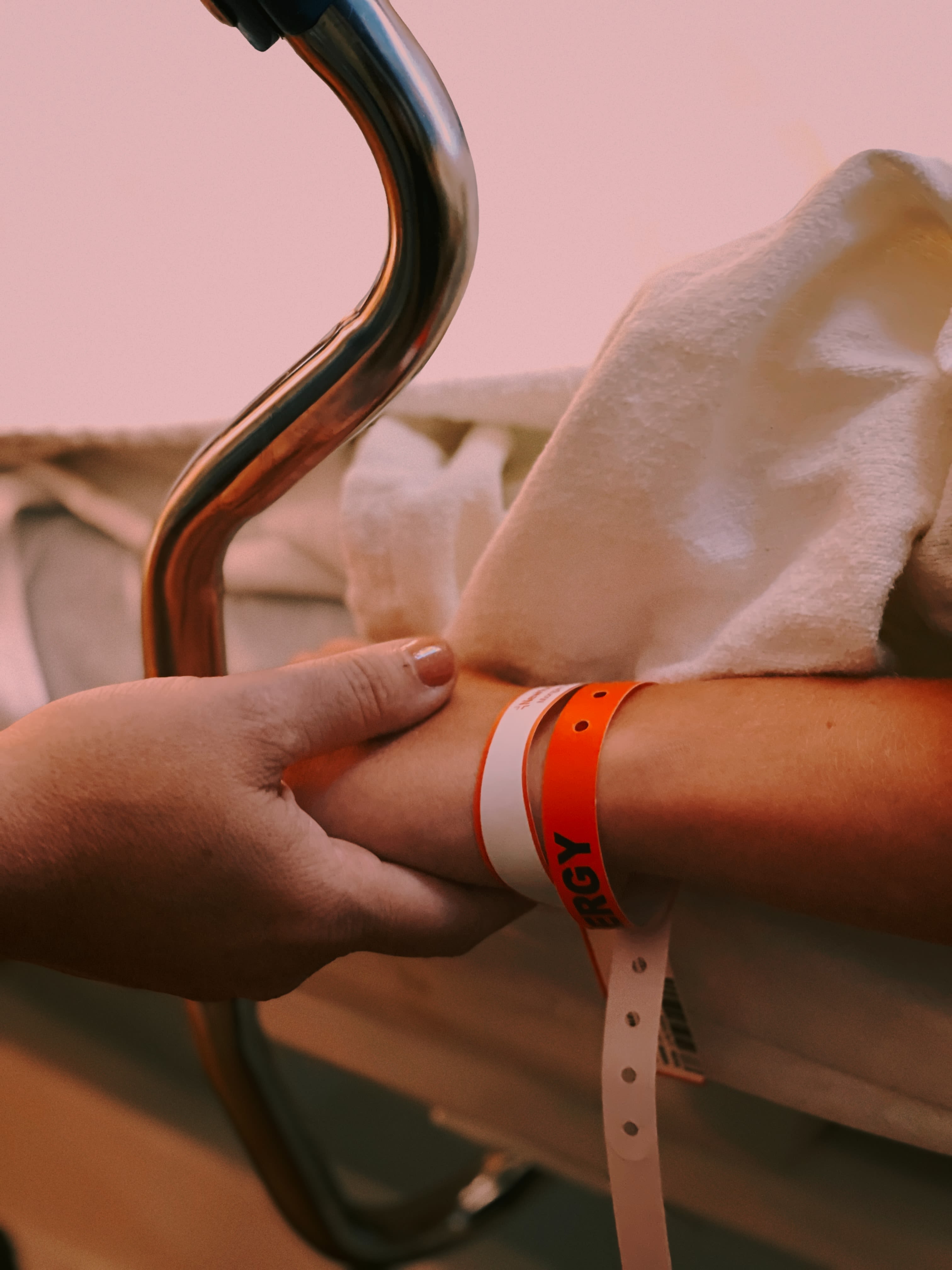 A parent holding a child's hand as they wait for surgery