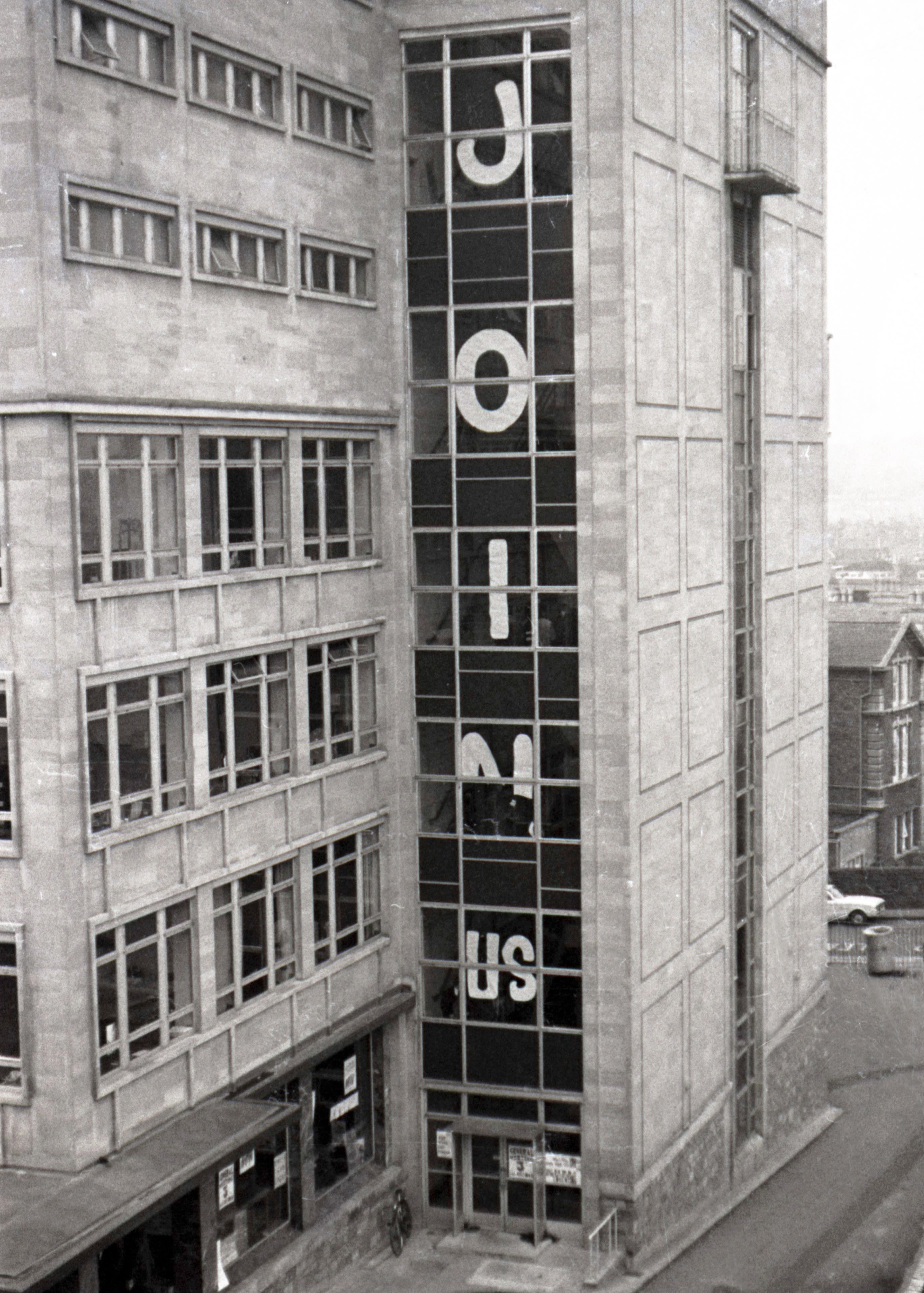 An image of Senate House, a University of Bristol building, in 1968. The words 'join us' are spelled out in large letters running down the side of the building.